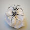 Beaded wire spider ornament featuring black seed beads, silver metal accents, and crystal-style details.